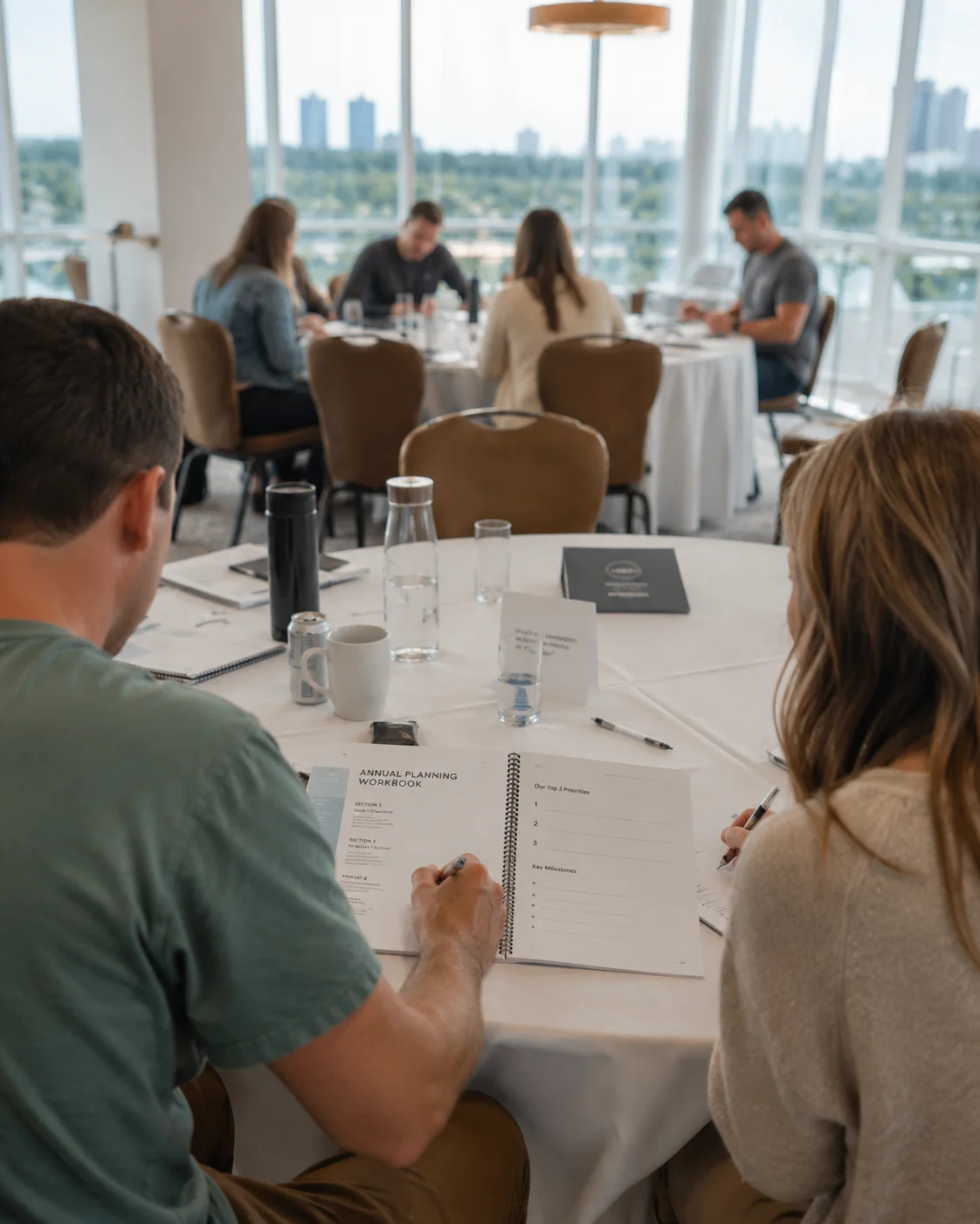 annual planning workshop in session Business owners working through an annual planning workbook during a planning session in a bright meeting space